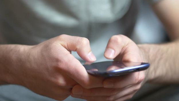 A: Tomar el teléfono con ambas manos en posición vertical