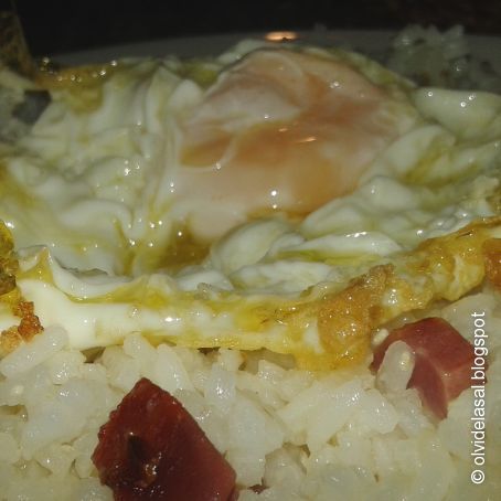 Huevo sobre cama de arroz frito al ajo y lomo