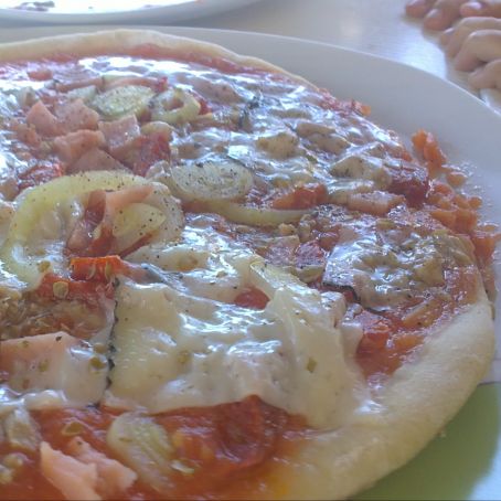 Masa de pizza casera y pizza hecha en la sartén