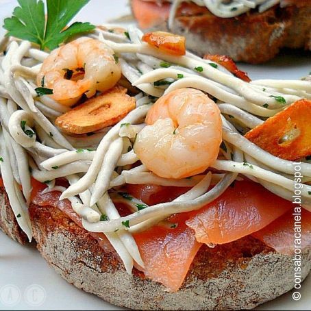 Tosta de salmón ahumado con gulas y gambas al ajillo