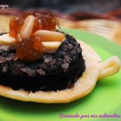 Tapa de morcilla con queso de cabra, piñones y cebolla confitada sobre plato de hojaldre